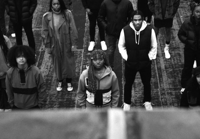 a group of people walking down a street next to each other