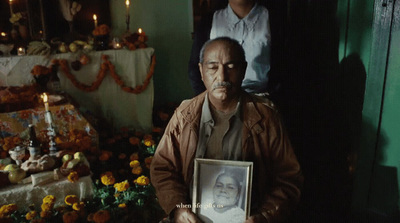 a man holding a picture of himself in front of flowers