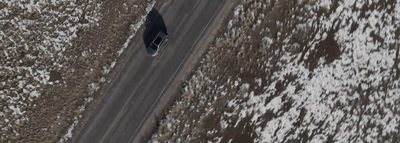 an aerial view of a car on a snowy road