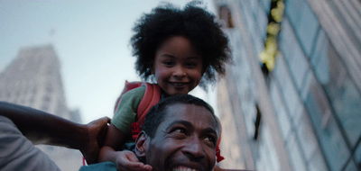 a man carrying a little girl on his shoulders