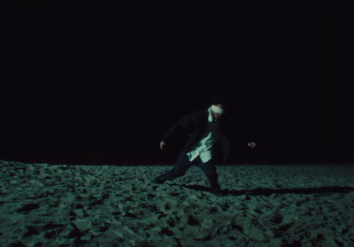 a man is running on the beach at night