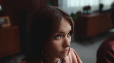 a woman sitting in front of a man in a living room