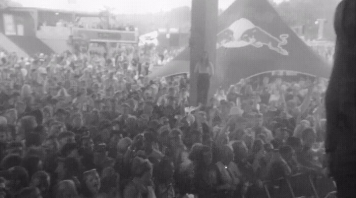 a crowd of people standing around a stage