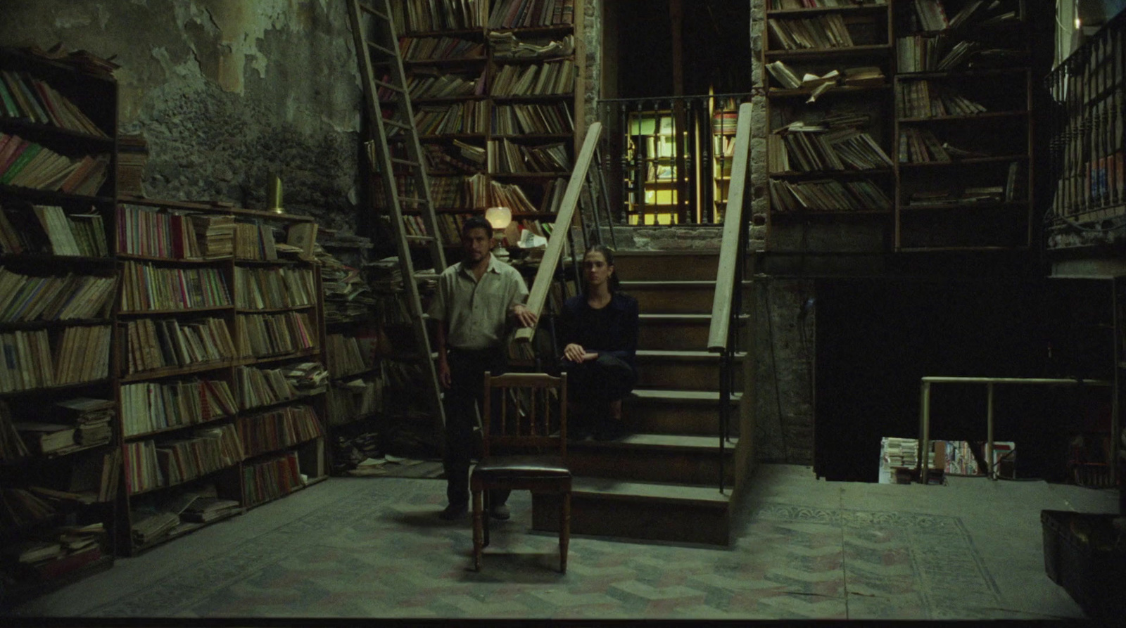 a man and a woman standing in a room full of books