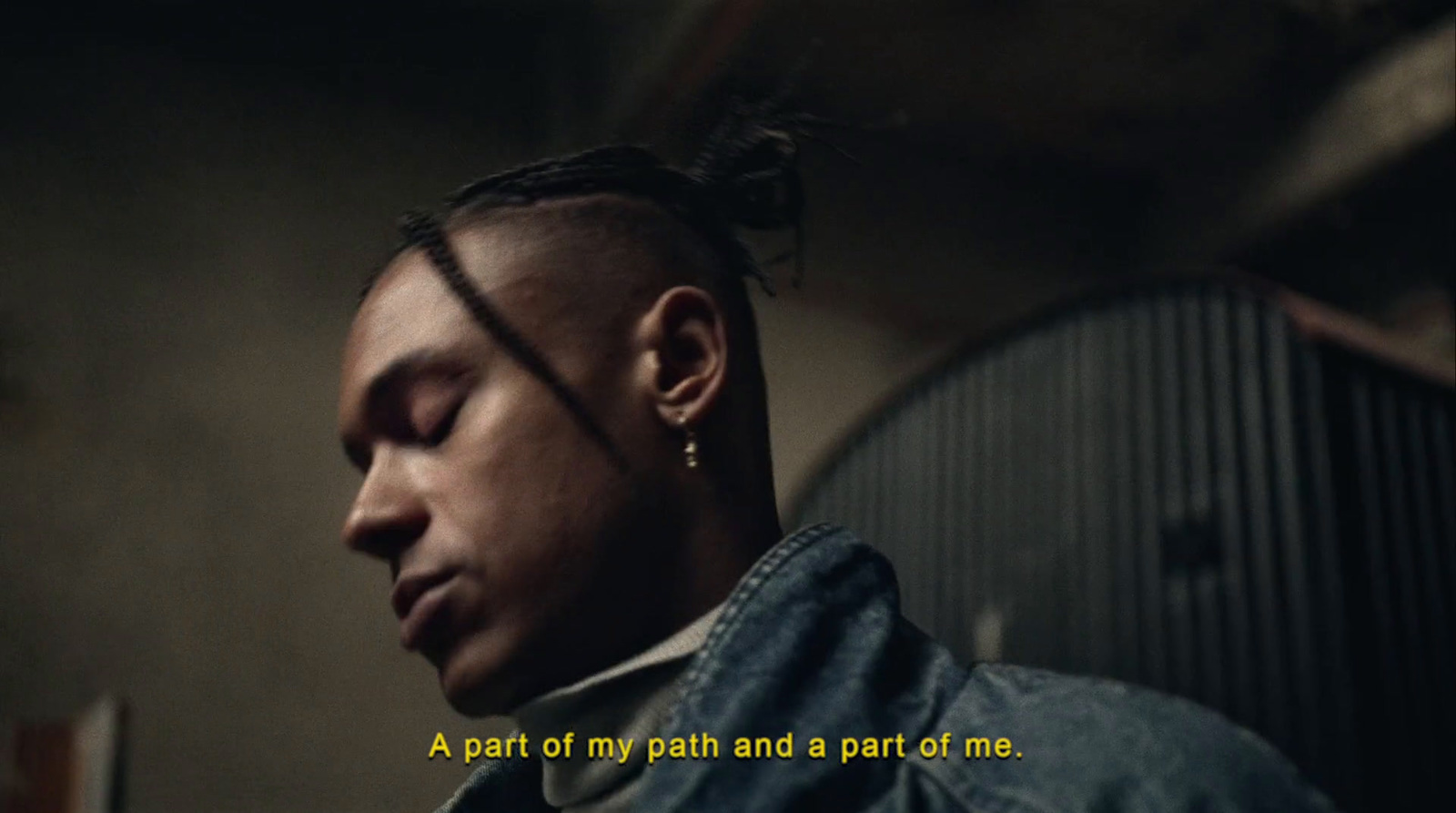 a man with dreadlocks and a denim jacket