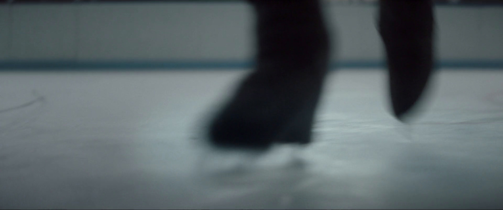 the legs of a person skating on an ice rink