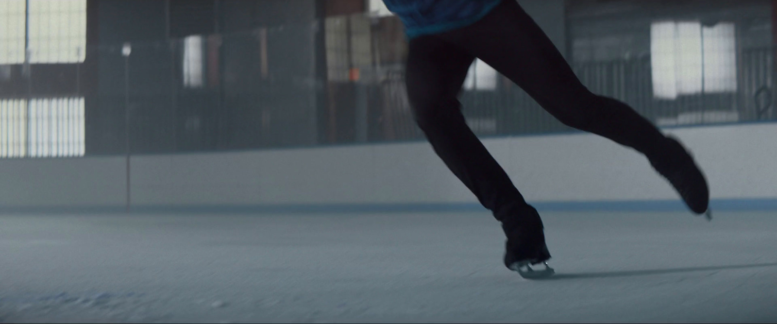 a skateboarder in a blue shirt is doing a trick