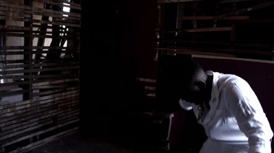 a man standing in a dark room next to a wall