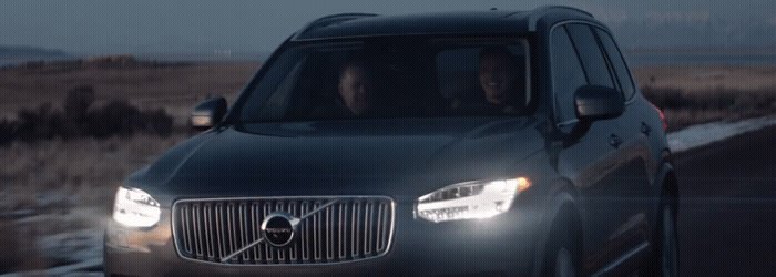 a volvo car driving down a road at night