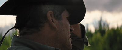 a man wearing a hat with a sky in the background