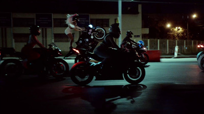 a group of people riding motorcycles at night