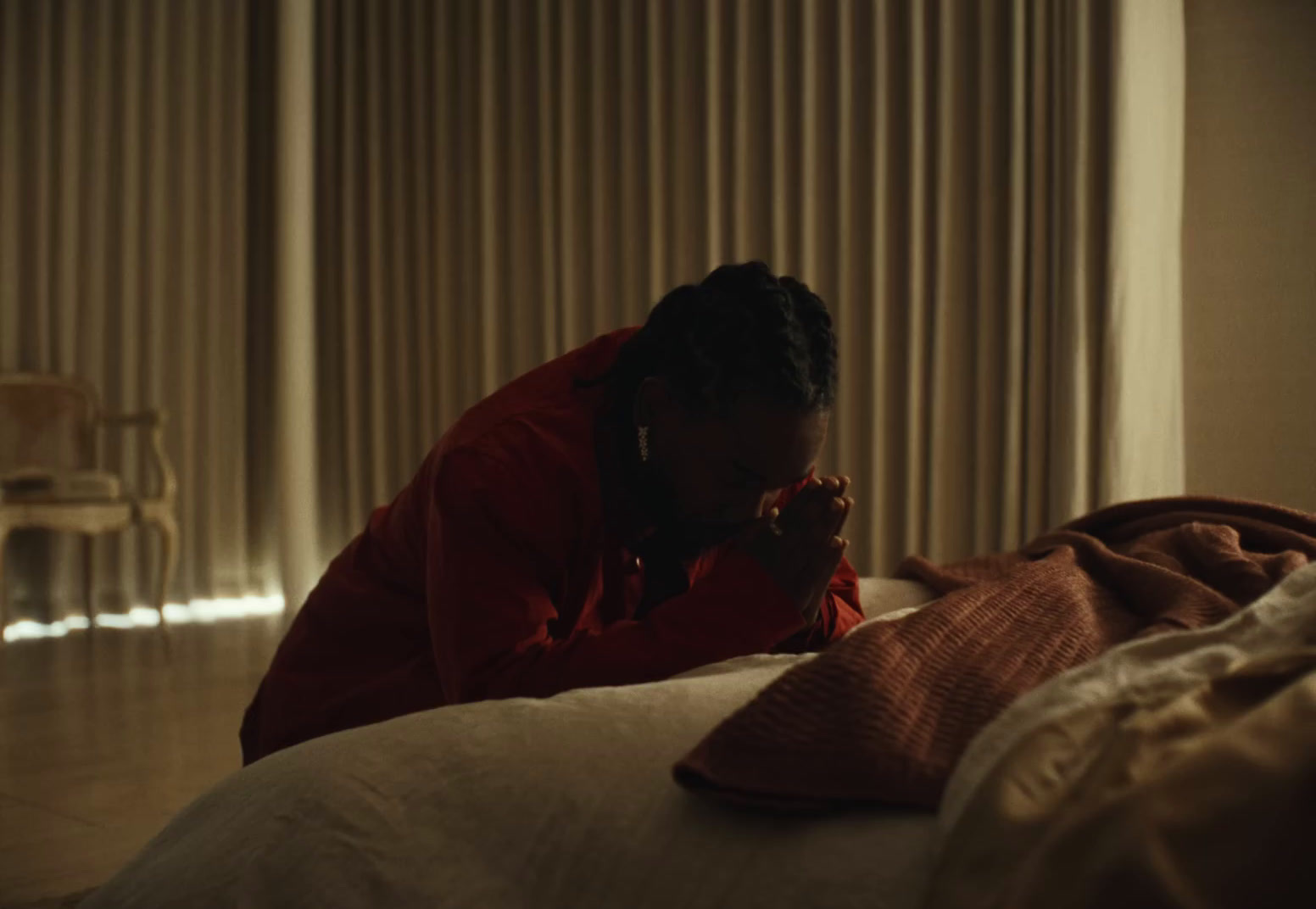 a woman in a red jacket laying on a bed