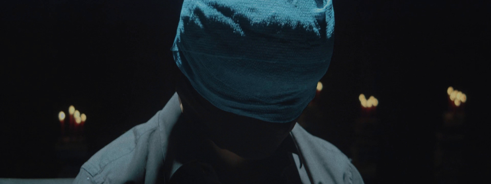 a man wearing a blue mask in the dark