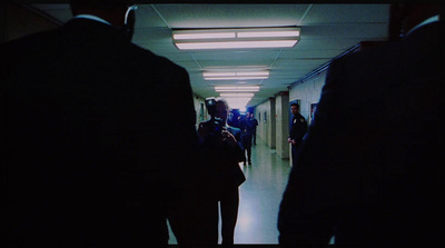 a group of people walking down a long hallway