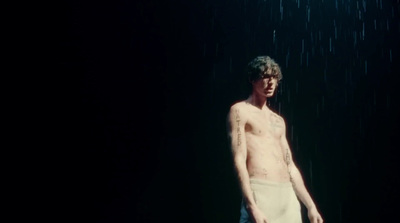 a man standing in the rain with no shirt on