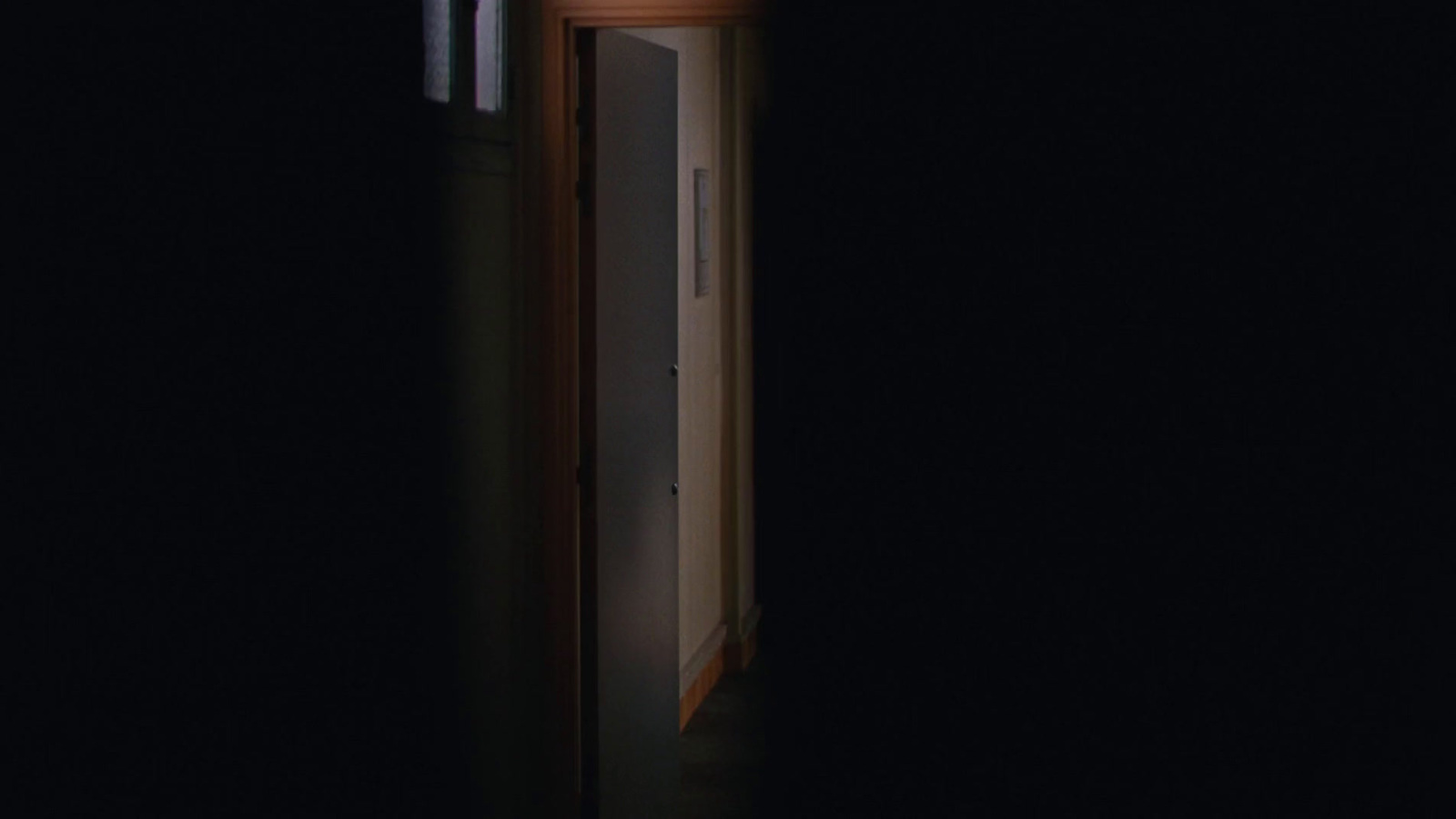 an open door in a dark room with a clock on it