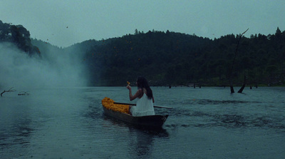 a woman sitting in a canoe on a lake