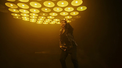 a man standing in front of a yellow light