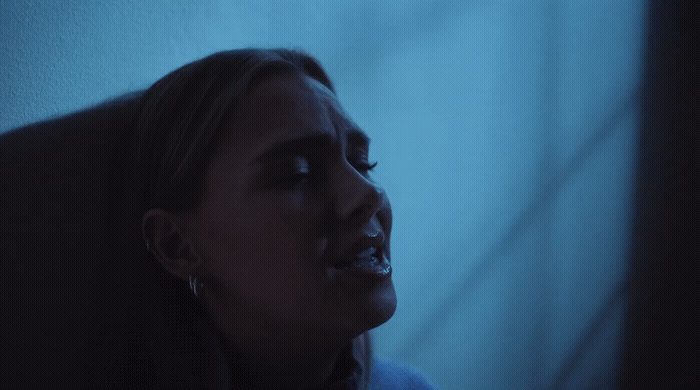 a woman with her mouth open in a dark room