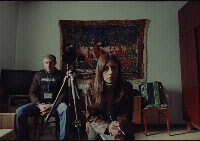 a man and a woman sitting in front of a camera