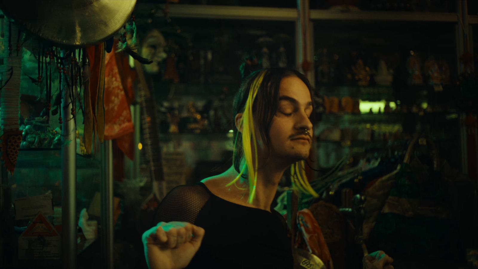 a man with long blonde hair standing in a room