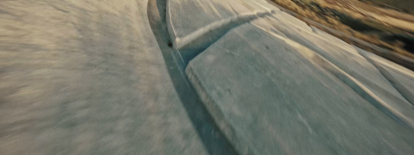 a man riding a snowboard down the side of a snow covered slope