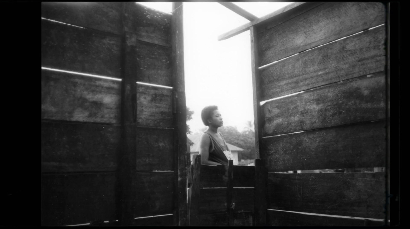 a black and white photo of a person standing in a doorway