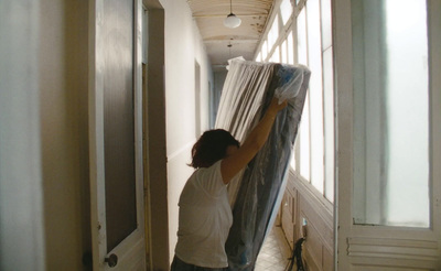 a woman moving a curtain in a hallway