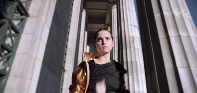 a woman in a black dress standing in front of a building