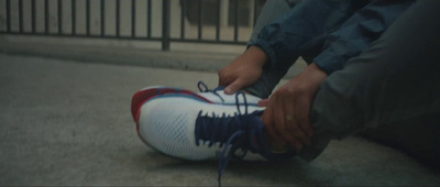 a person tying a shoelace on a pair of shoes