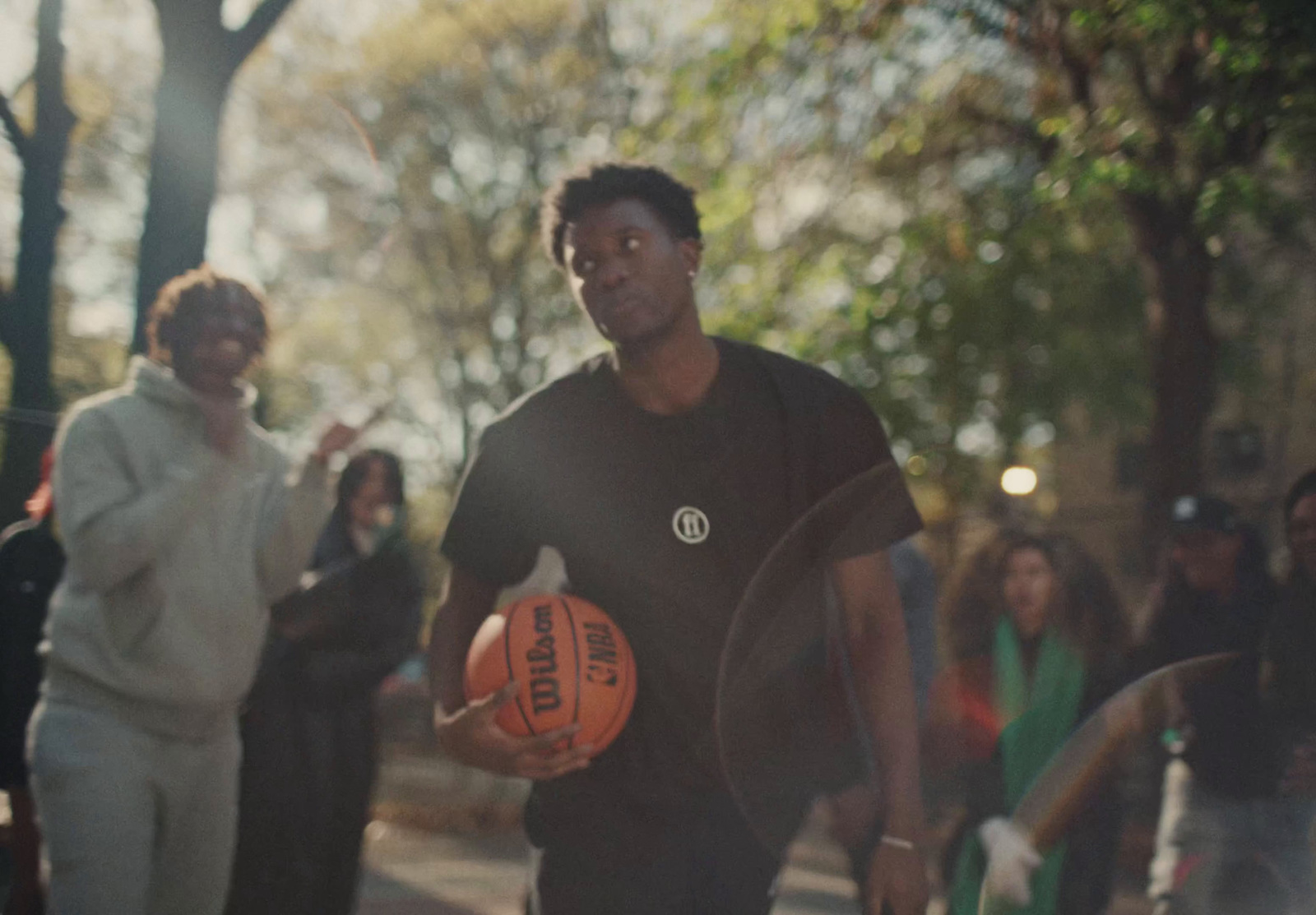 a man holding a basketball while walking down a street