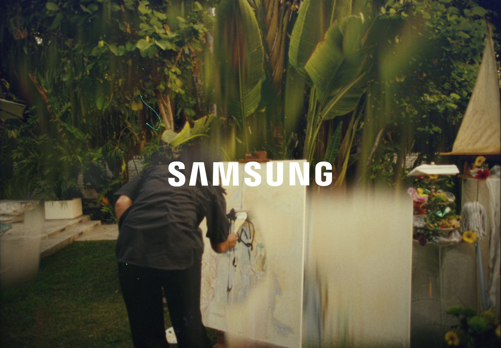 a man painting a picture with the words samsung on it