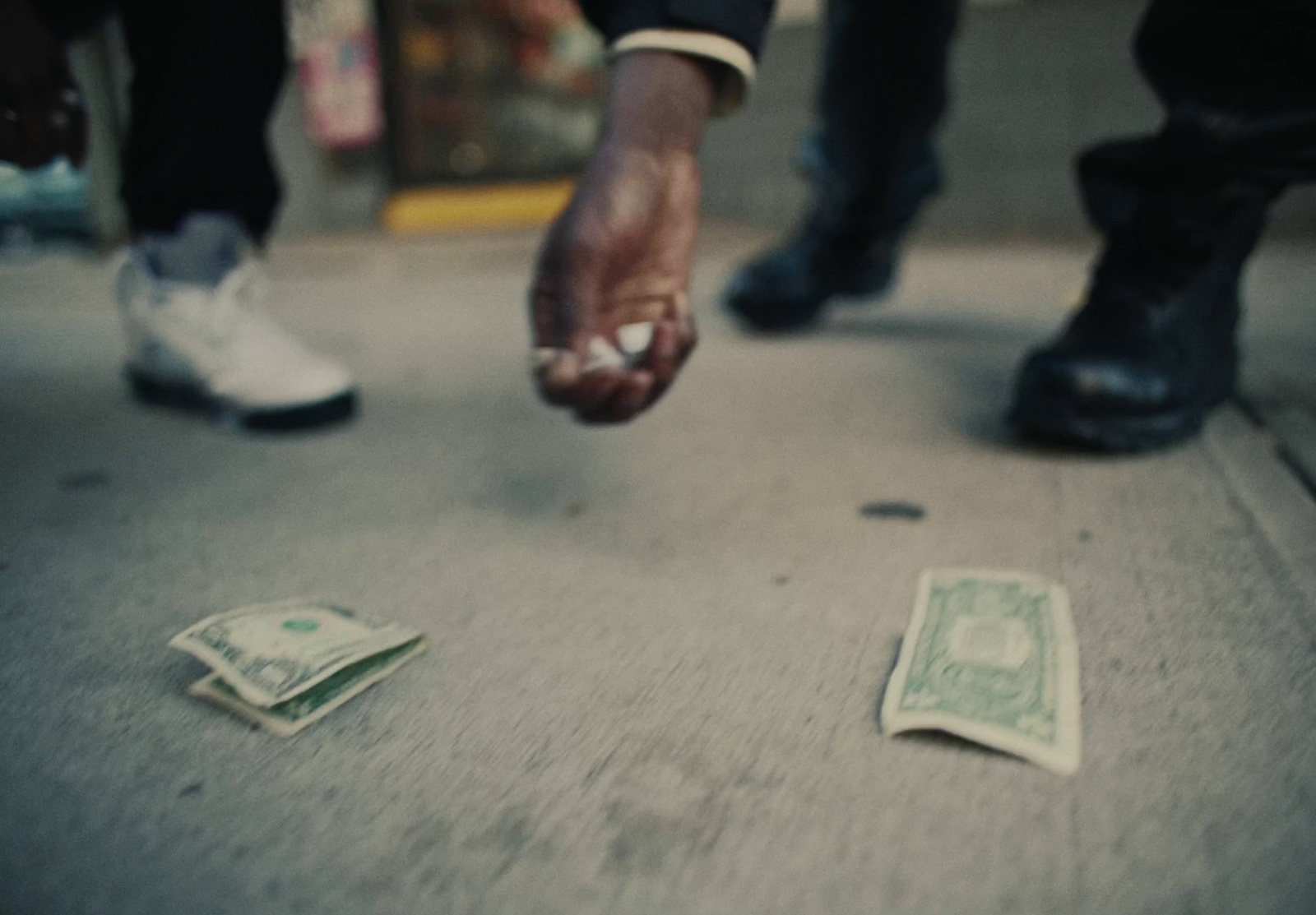 a person reaching for money on the ground