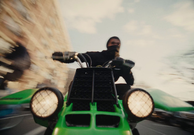 a man riding on the back of a green motorcycle