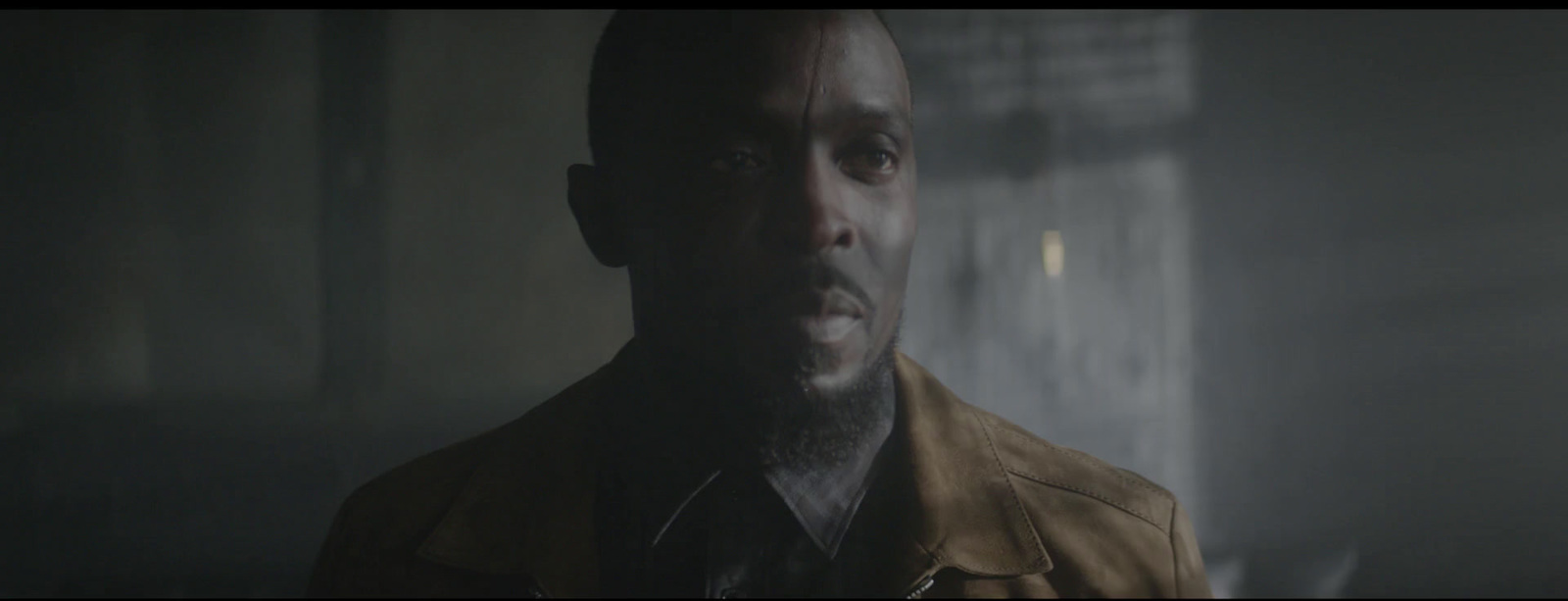 a man standing in a dark room looking at the camera