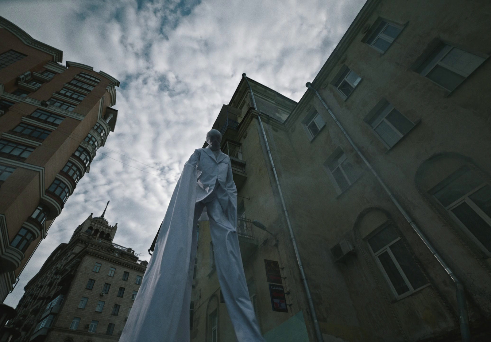 a statue of a man standing in front of a tall building