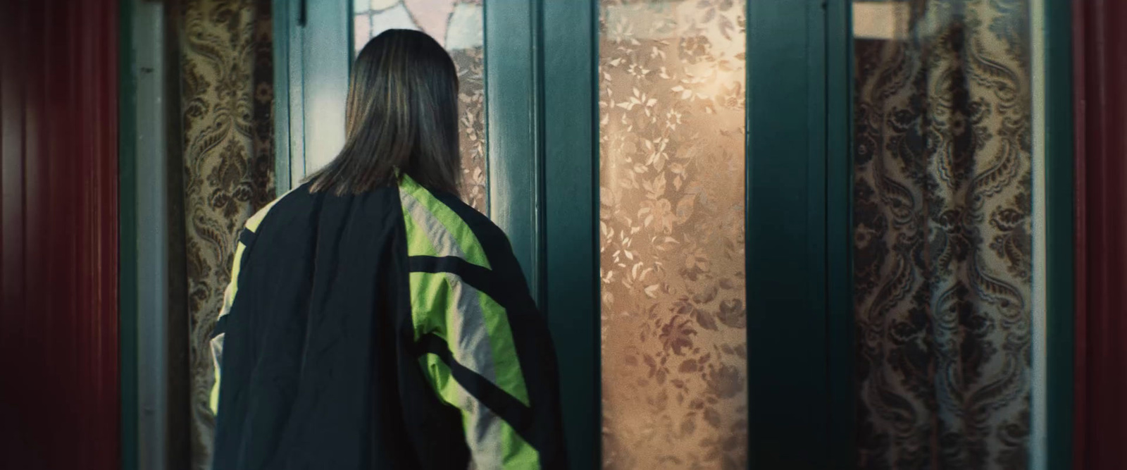 a woman standing in front of a green door