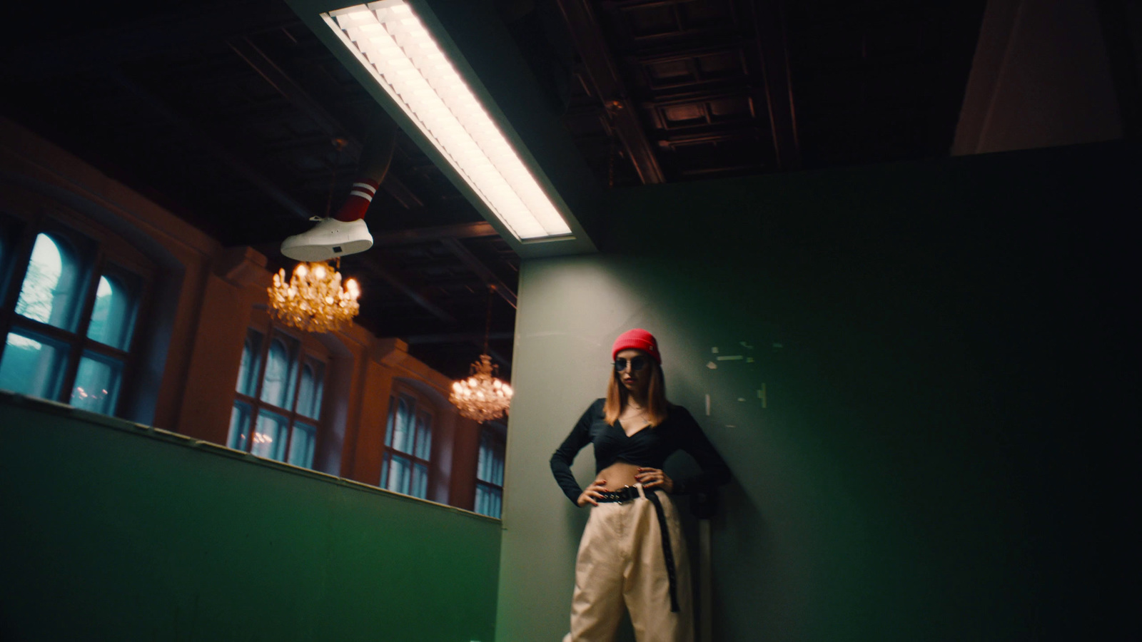 a woman standing next to a green wall