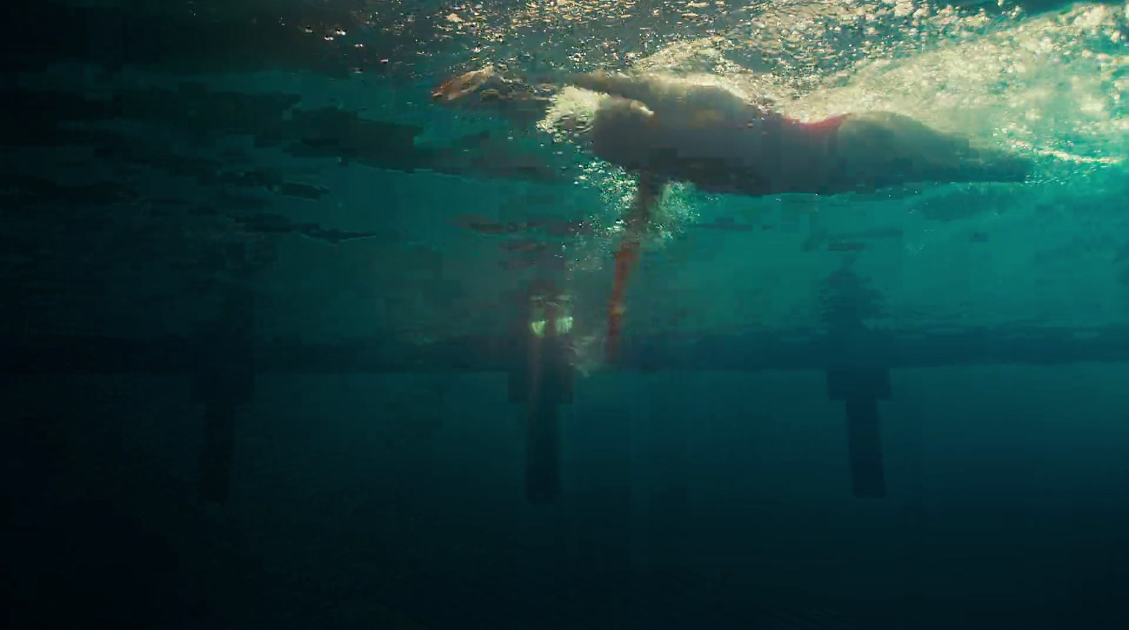 a person swimming under water in a pool