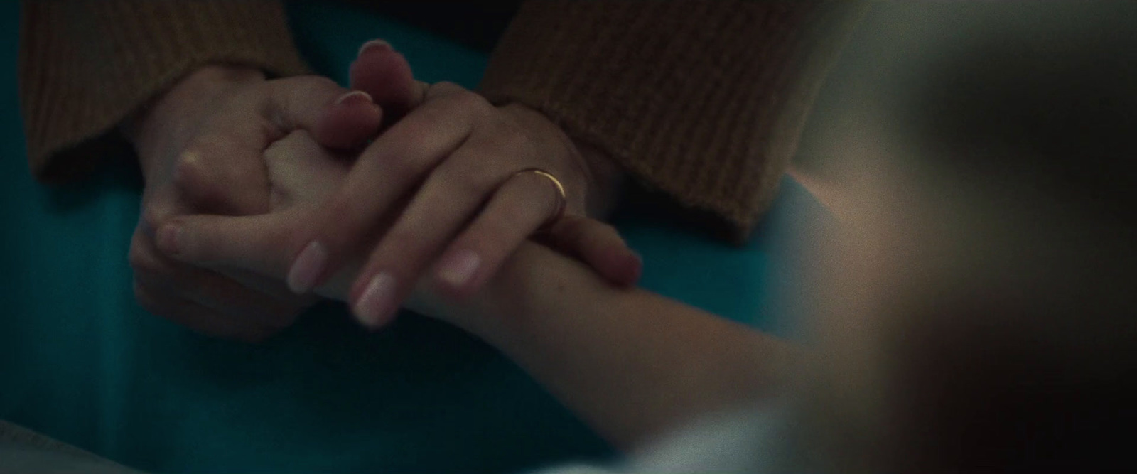 a close up of two people holding hands