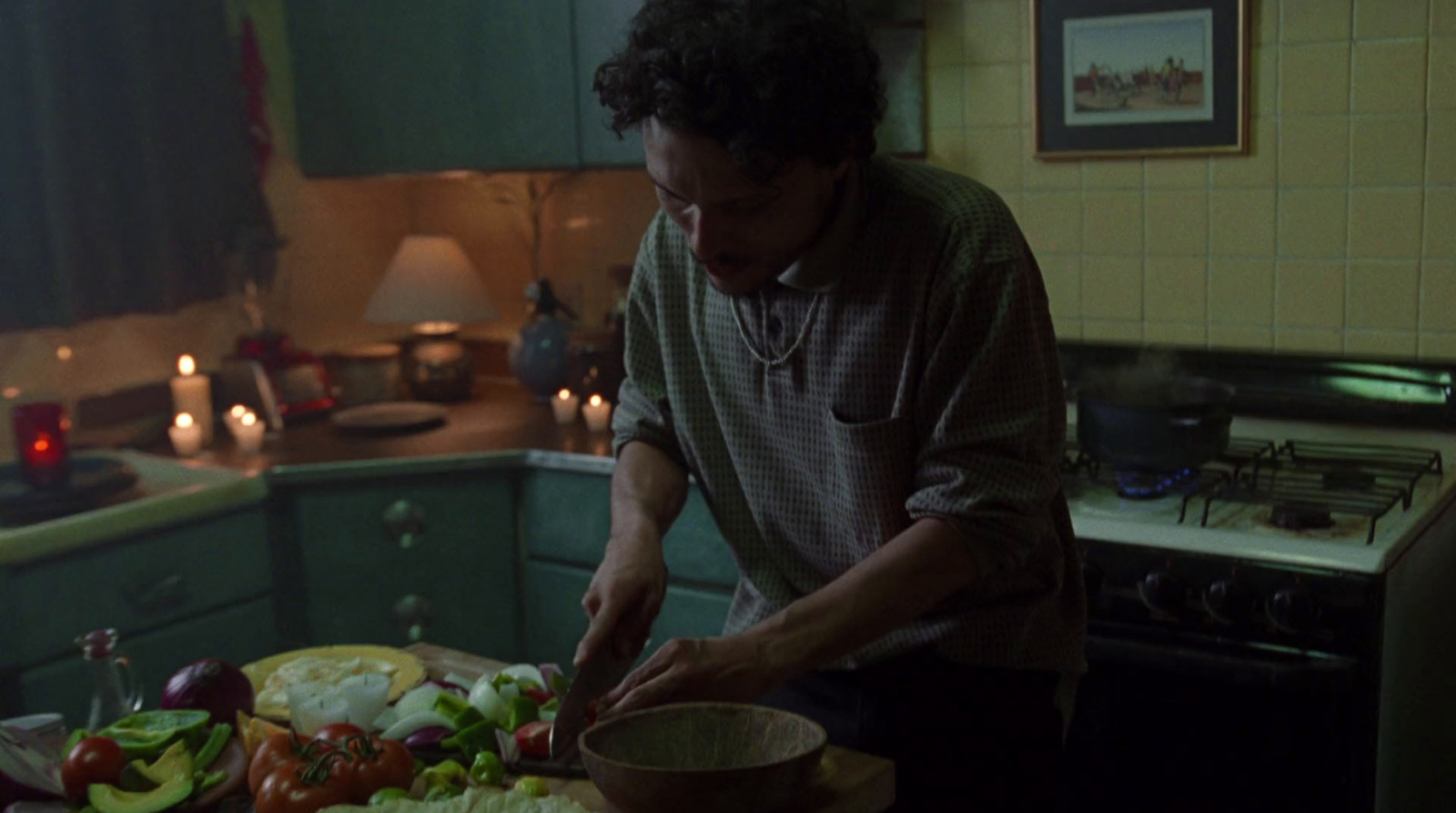 a man cutting vegetables on a cutting board in a kitchen