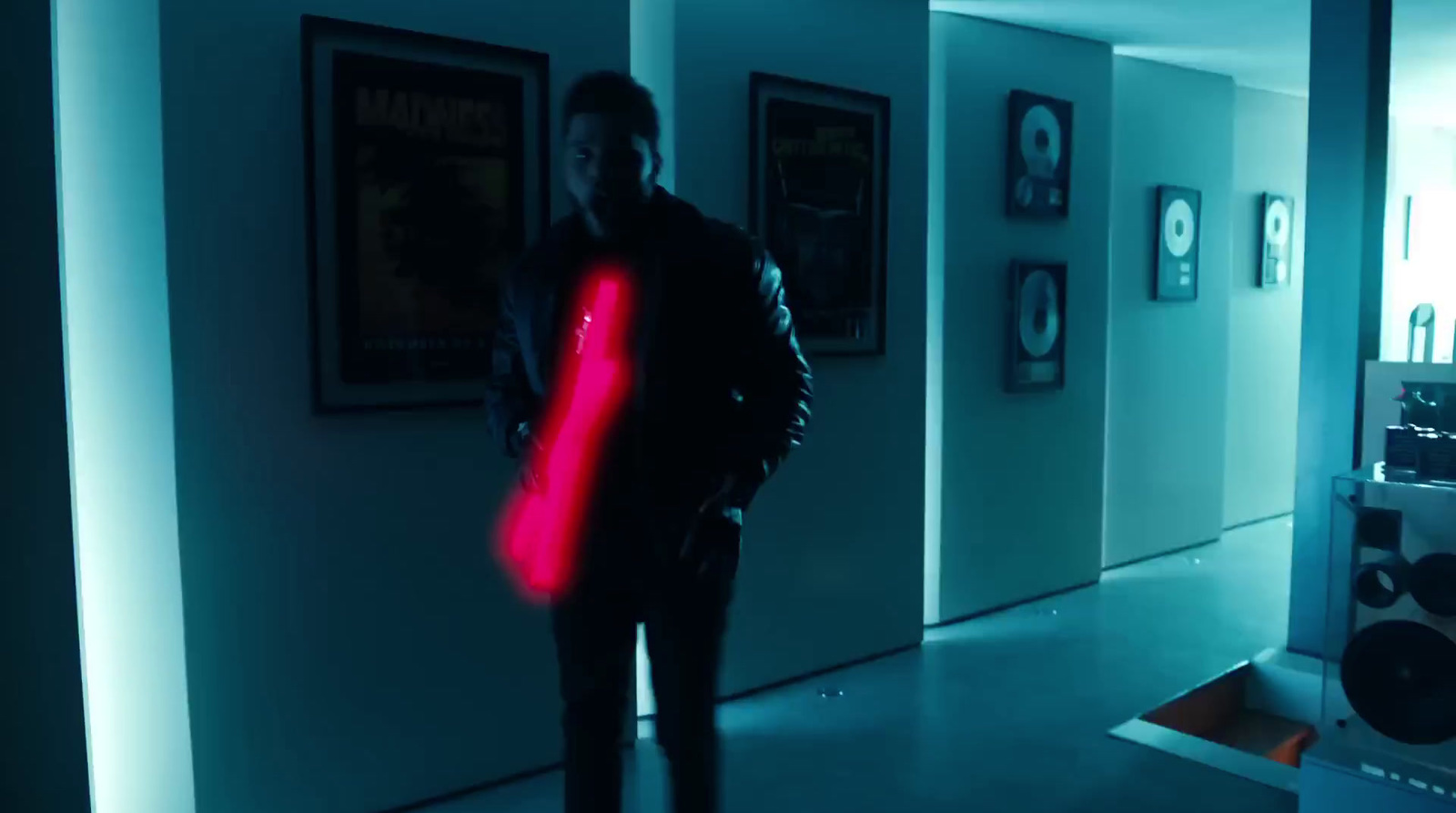 a man standing in a hallway holding a red object