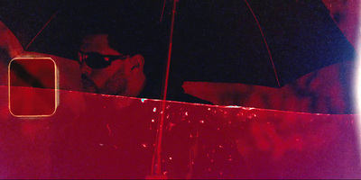 a man with sunglasses and a black umbrella