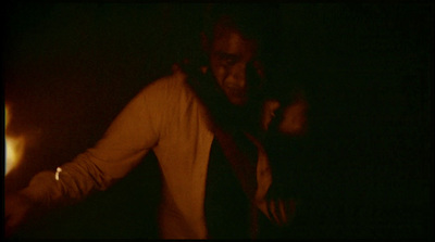 a man standing in a dark room with his hands on his hips