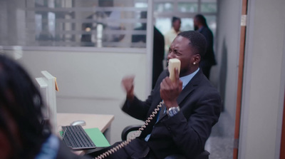 a man sitting in a chair talking on a phone