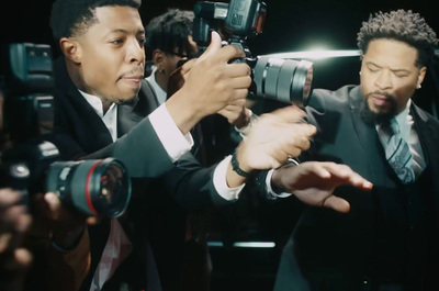 a group of men standing next to each other in front of a camera