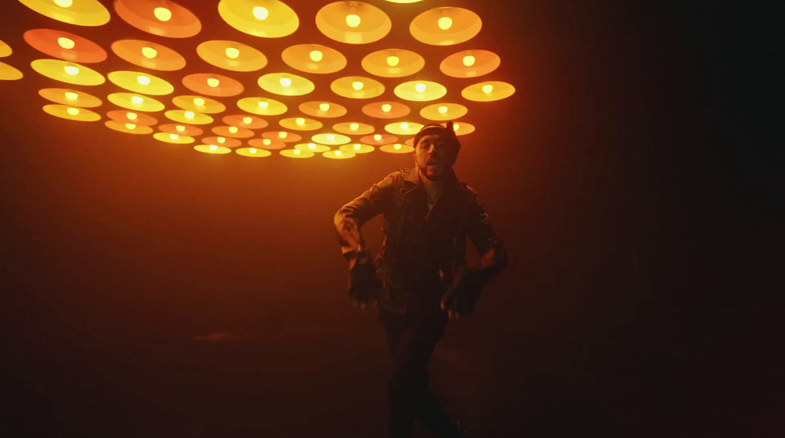 a man standing in front of a light filled ceiling