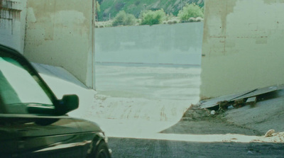 a car parked in front of a building under construction