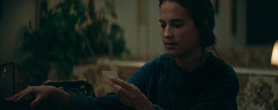 a woman sitting at a table looking at her cell phone