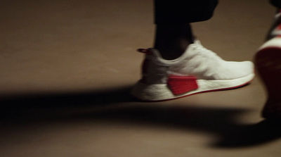 a close up of a person's feet wearing white and red sneakers